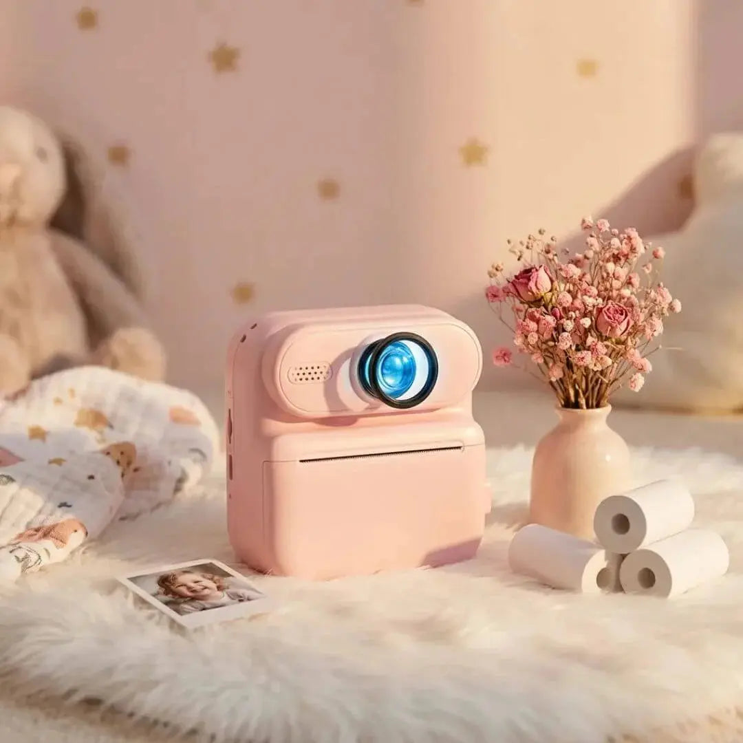 Appareil photo enfant rose avec rouleaux papier thermique fleurs séchées ambiance chambre douce