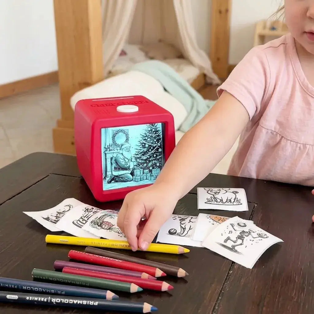 Fillette attrapant ses impressions thermiques collectionnées devant l'imprimante cube rouge