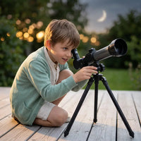 Garçon utilisant un télescope enfant sur une terrasse au crépuscule